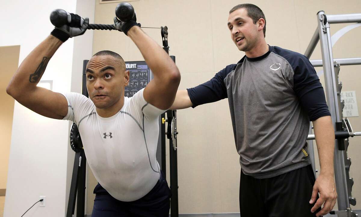 Baron Lambert, right, works with his client, Chris Barbour, at Barbour's condominium gym in San Francisco, Calif., on Wednesday, October 5, 2016. Lambert left his regular job as a fitness trainer at 24-Hour Fitness to go into business for himself, similar to many americans in recent years.