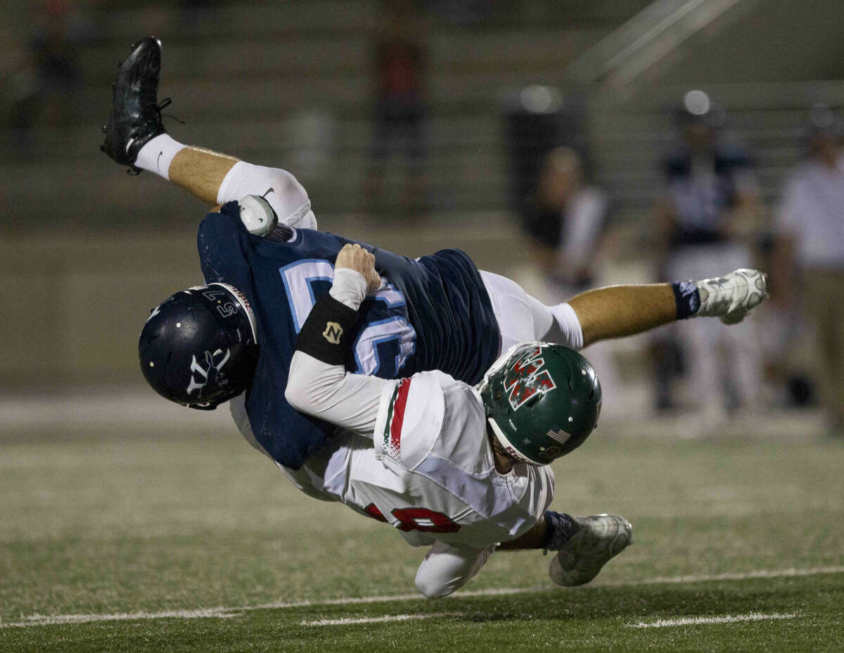 Kingwood's Benn Beckelman drives The Woodlands quarterback Harry Woodberry into the ground in the fourth quarter of a District 16-6A football game November 5, 2015, in Humble. To view or purchase this photo and others like it, visit HCNpics.com.