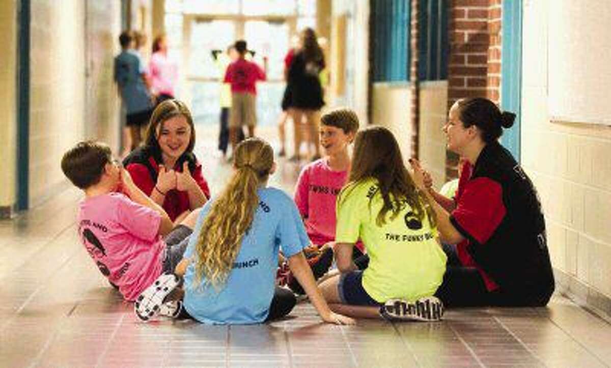 The Woodlands High School Improv Troupe members Katerina Meyerl and Brenna Lelicah laugh as Mitchell Intermediate School students Rotem Rics and Jason Leach go through a skit at Mitchell Intermediate School Wednesday.