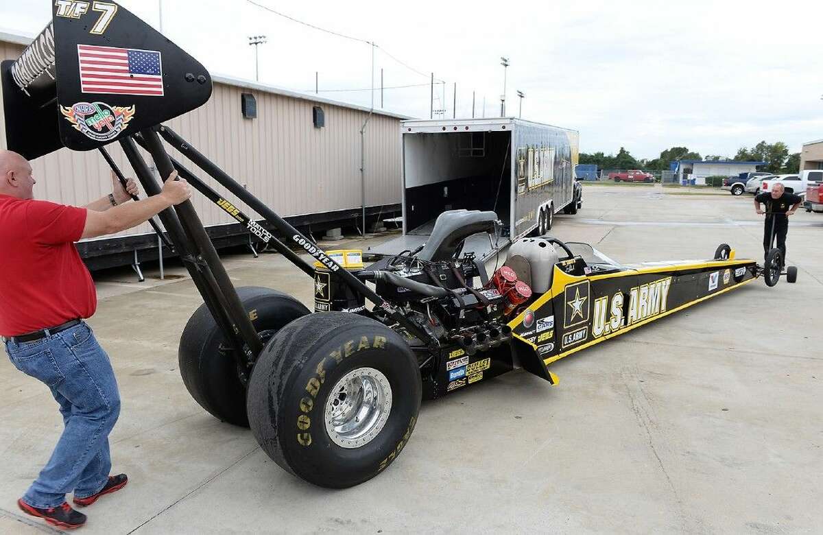 Automotive instructor Gary Miller and Schumacher Racing representative Todd Gauthier unload the U.S. Army dragster from the trailer on Nov. 6 at Cypress Creek High School.