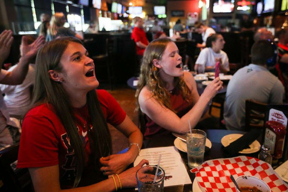 Caroline Welch and Claire Andrews, teammates of diver Kassidy Cook, watch her qualifying trial for the U.S. Olympic team on Sunday, at Stadia Sports Grill.