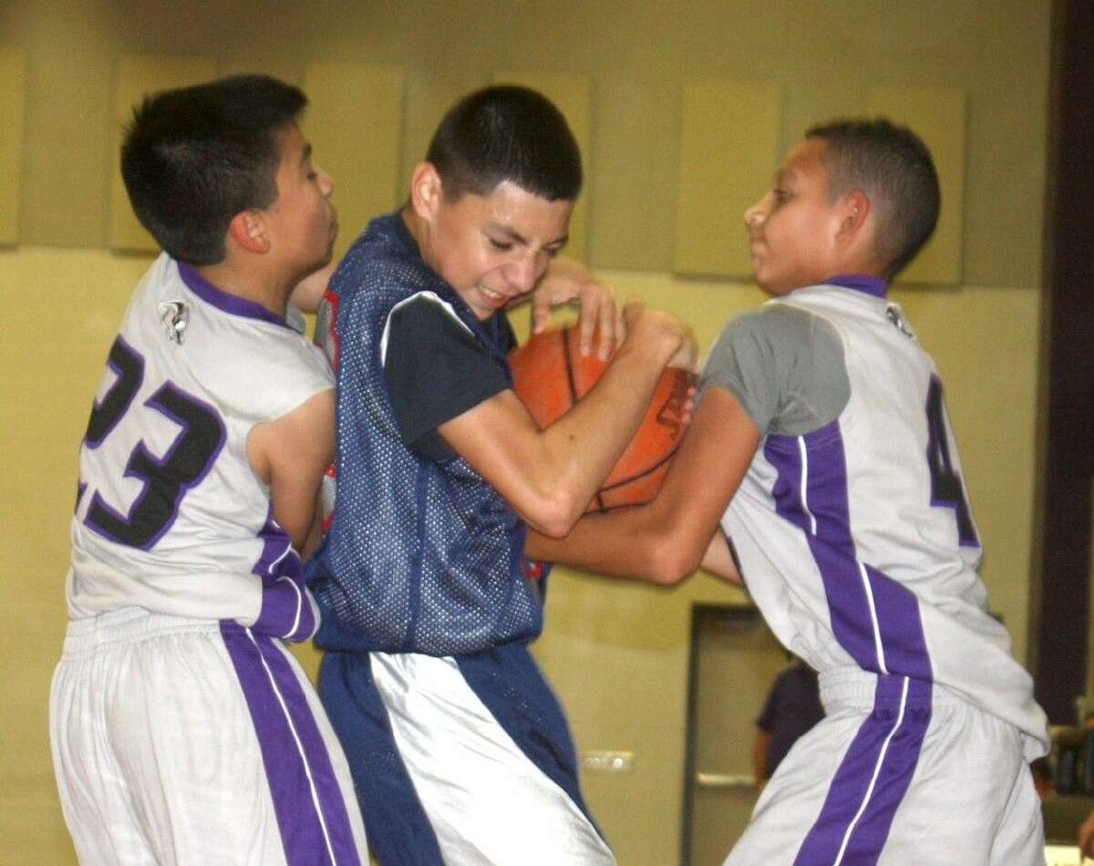 Bondy Intermediate's Elias Castro is sandwiched by Southmore's Javier Carona (23) and Donovan Berotte as Castro attempts to prevent a jump ball. The Bulldogs were whistled for a foul on the play during second-half action Wednesday night.