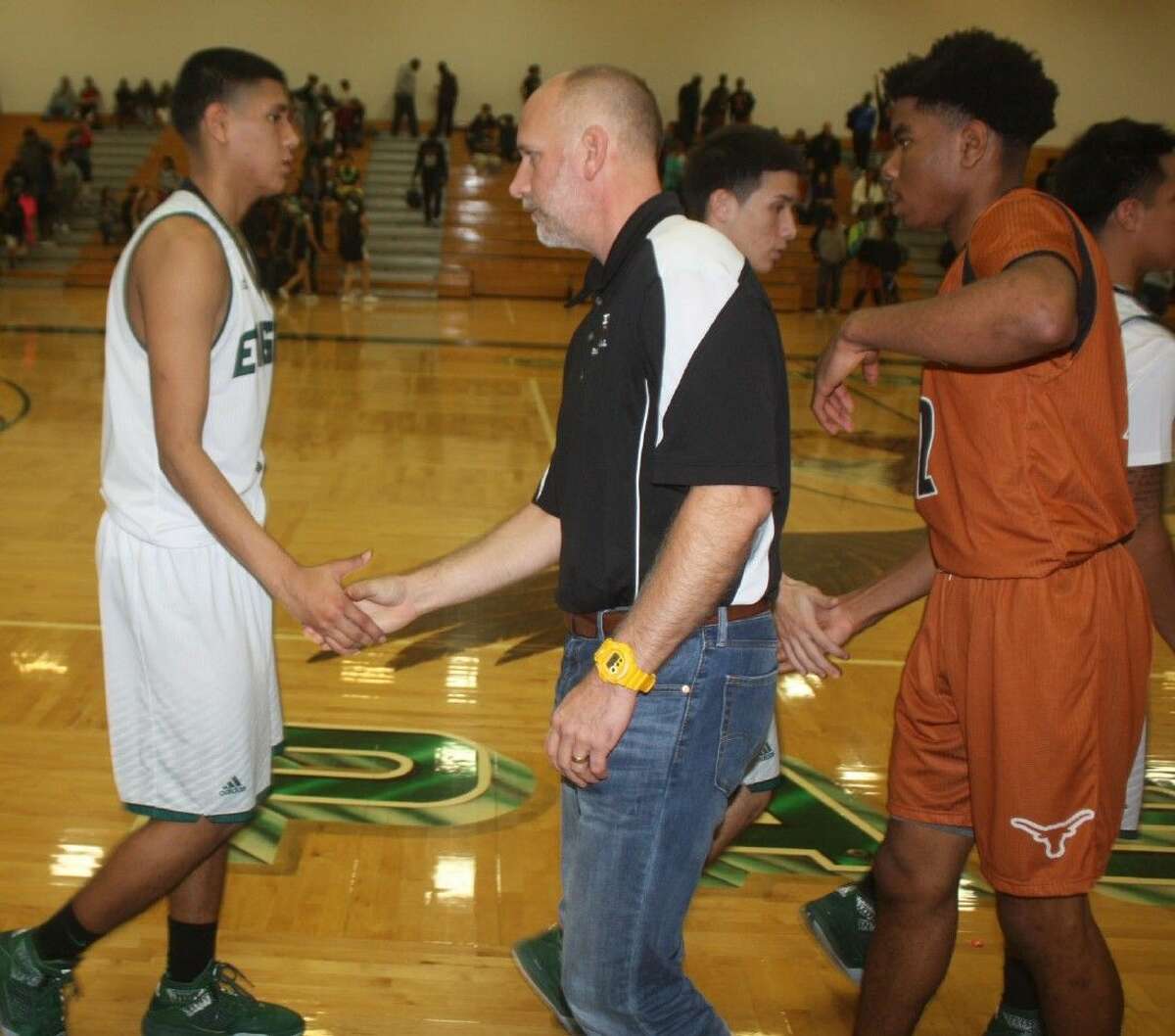 Dobie head coach Kevin Cross and his players shake hands with the Eagles, following the team's narrow 22-6A win Friday night.