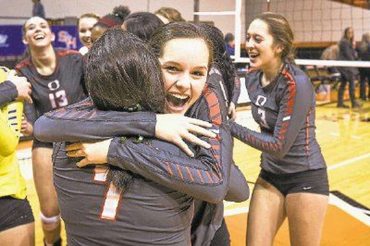 Oak Ridge’s Lexi Overman (2) and Sarah Smedley (7) hug after their victory over The Woodlands during the high school volleyball game on Saturday at Johnson Coliseum.