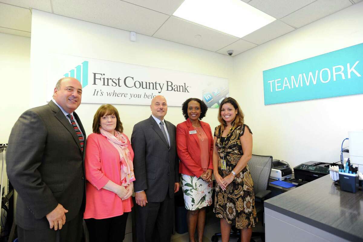 From left, First County Bank president and COO Bob Granata, First County Bank VP Sandy Holbrook, First County Bank senior VP Willard Miley, branch manager Sheila Content and AITE principal Tina Rivera pose inside AITE's new First County Bank limited-access branch in Stamford, Conn. on Wednesday, Oct. 5, 2016.