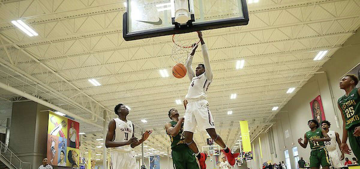 Walter Whyte hangs on the rim after a dunk during an AAU game with the PSA Cardinals. Whyte, a senior at St. Luke's committed to Boston University on Tuesday.