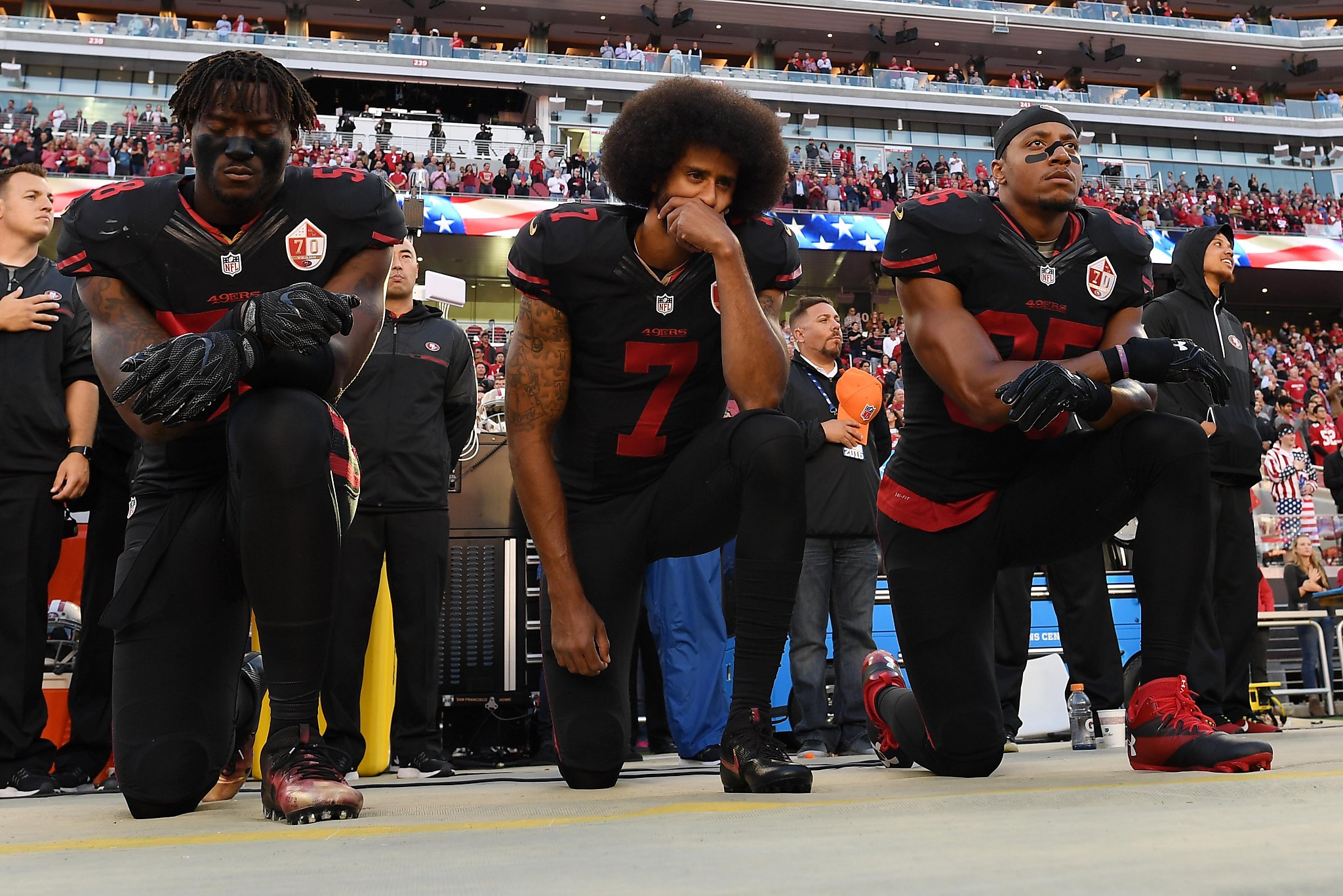 From left, The San Francisco 49's Eli Harold (58), Colin Kaepernick (7) and  Eric Reid (35) kneel during the national anthem before their a game against  the Dallas Cowboys on October 2