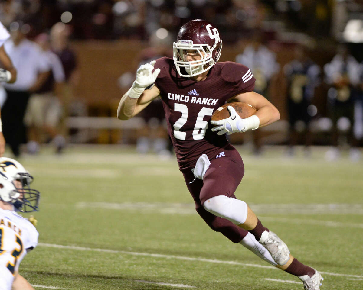 Ethan Cook (26) of the Cinco Ranch Cougars advances a pitch from quarterback James Klingler (12) during the third quarter of a high school football game versus the Cy Ranch Mustangs on Friday, August 26, 2015, at Rhodes Stadium.