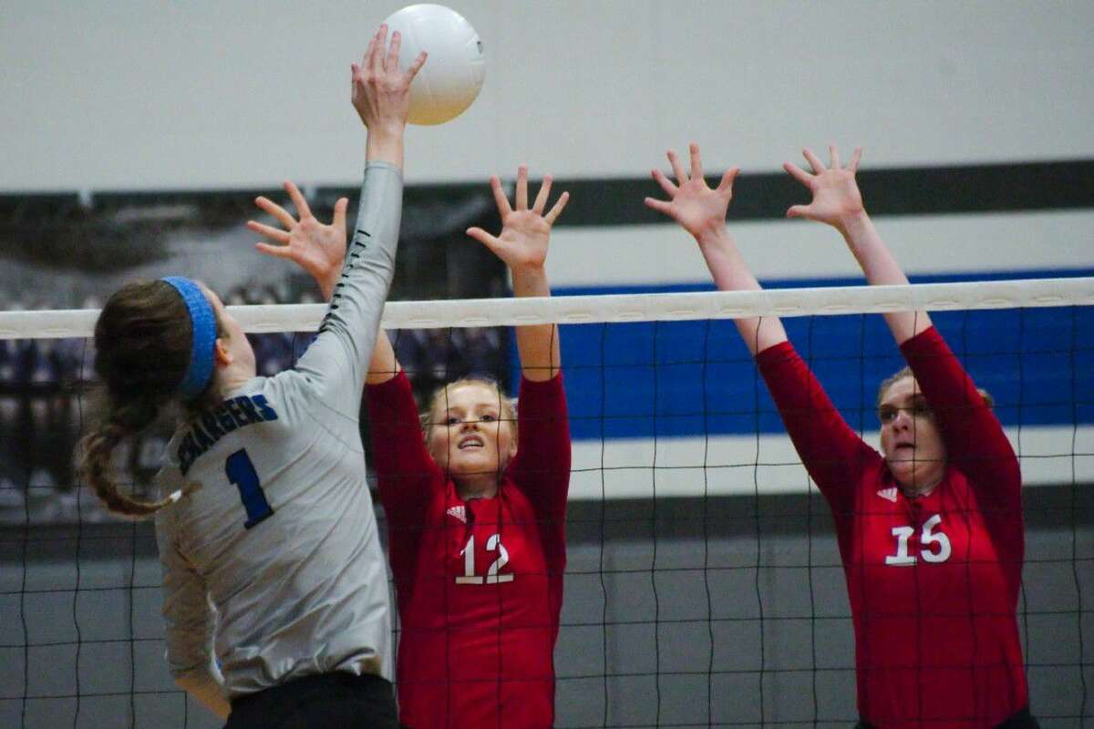 Dawson's Katelynn Tripp (12) and Kate Plummer (15) go high to block a shot by Clear Springs' Lauren Burt (1) on Tuesday, Sept. 6, Tripp's final game with the Lady Eagles this season.