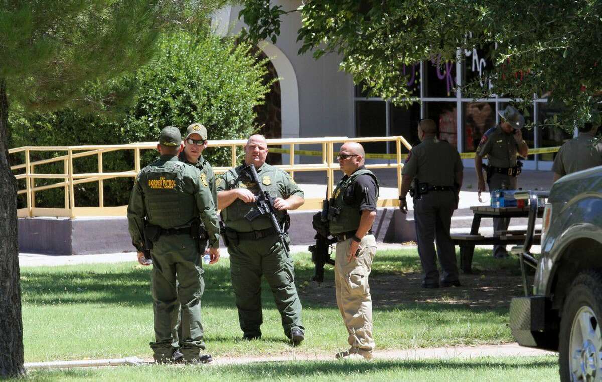 United States Border Patrol officers and Texas Department of Public Safety officers secure the perimeter around Alpine High School, Thursday in Alpine. A 14-year-old girl died of an apparent self-inflicted gunshot wound after shooting and injuring another female student Thursday inside the school, according to the local sheriff.