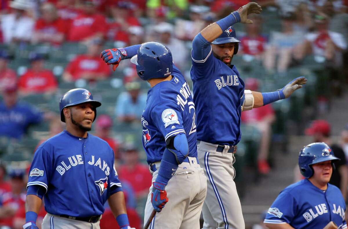 The Toronto Blue Jays' Troy Tulowitzki (2) and Jose Bautista (19) celebrate Bautista's three-run home run in the ninth inning against the Texas Rangers in Game 1 of the ALDS at Globe Life Park in Arlington, Texas, on Thursday, Oct. 6, 2016. The Blue Jays won, 10-1. (Richard W. Rodriguez/Fort Worth Star-Telegram/TNS)