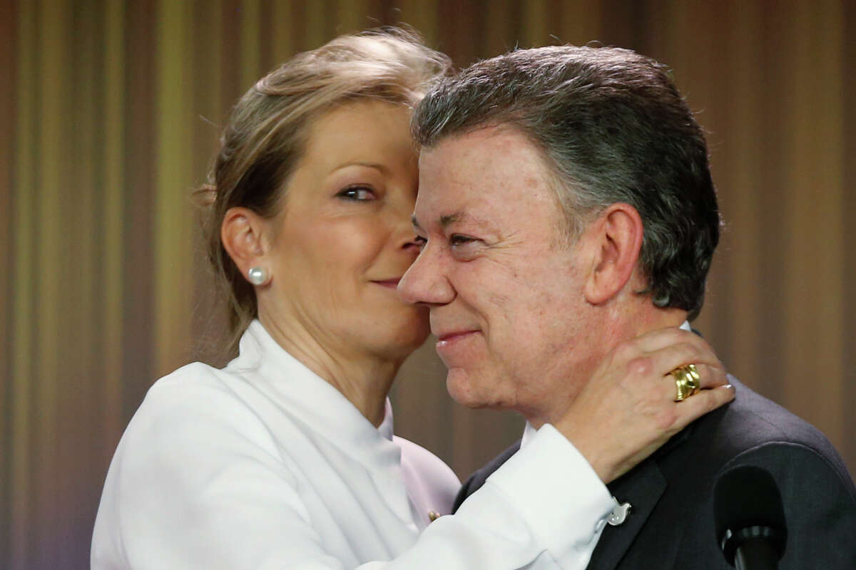 Colombia's President Juan Manuel Santos is embraced by his wife Maria Clemencia Rodriguez after speaking to journalists at the presidential palace in Bogota, Colombia, Friday, Oct. 7, 2016. Santos won the Nobel Peace Prize Friday, just days after voters narrowly rejected a peace deal he signed with rebels of the Revolutionary Armed Forces of Colombia, FARC. (AP Photo/Fernando Vergara)