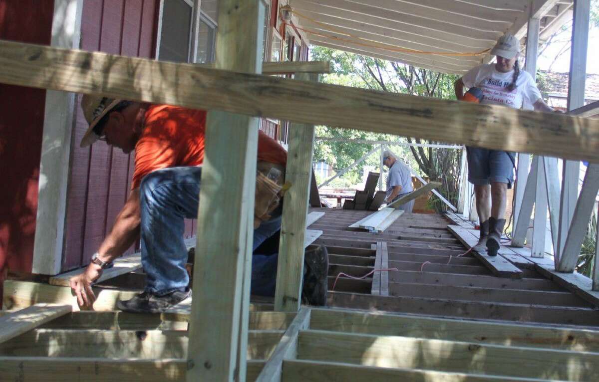 Mike Rayne (left) and Debbie Hanson (right) work on the boards of the Coldspring/San Jacinto County Chamber of Commerce office’s porch on Sept. 21.