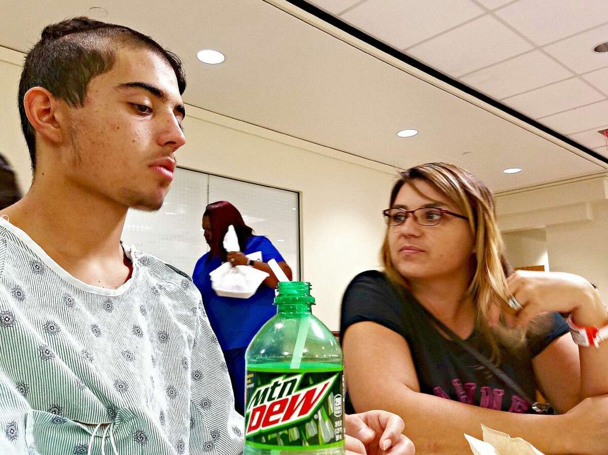 Shannon Mamo (right) sits with her son, Kyle Mamo (left), in the hospital, encouraging him to eat. Kyle and his parents spent 14 days in the hospital after he underwent surgery for an arachnoid Cyst on August 31.