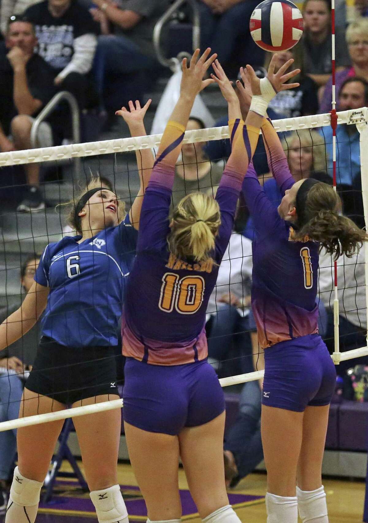 La Vernia’s Chloe Patton (left) pops the ball over Casey Bryan (10) and Allie Benner (1) of Navarro on Oct. 7, 2016.