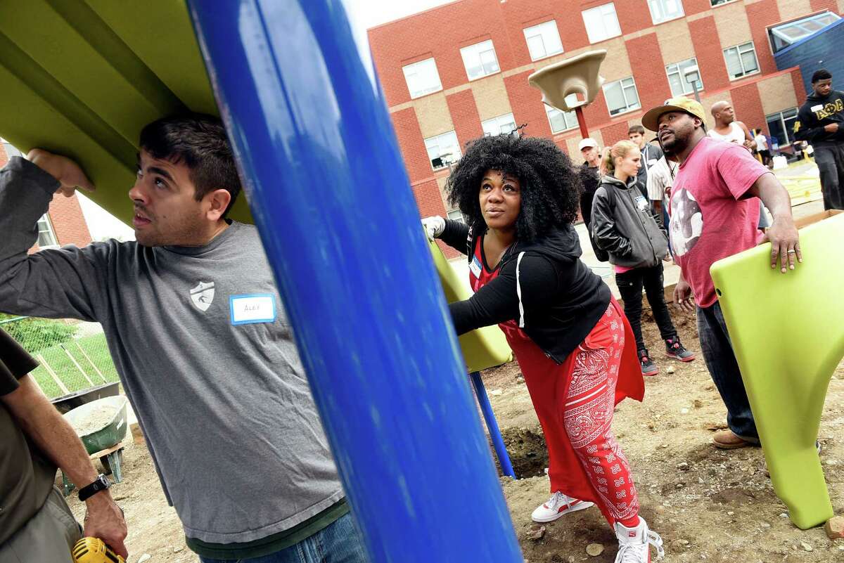 Alex Brown of Creighton Manning Engineering, left, joins Teresa and Earl Alford, whose children attend SPA, as they help put together a slide on the new playground on Saturday, Oct. 8, 2016, at Sheridan Preparatory Academy in Albany, N.Y. About 60 volunteers from the school and community came together to build the play space. Support for the project includes a $15,000 Let?’s Play Community Construction Grant from Dr. Pepper Snapple Group and national non-profit KaBOOM! SPA has raised $50,000 of its $60,000 goal for the project, and it has a Red Basket fundraising site to help raise the rest. To contribute, visit https://redbasket.org/1074 (Cindy Schultz / Times Union)