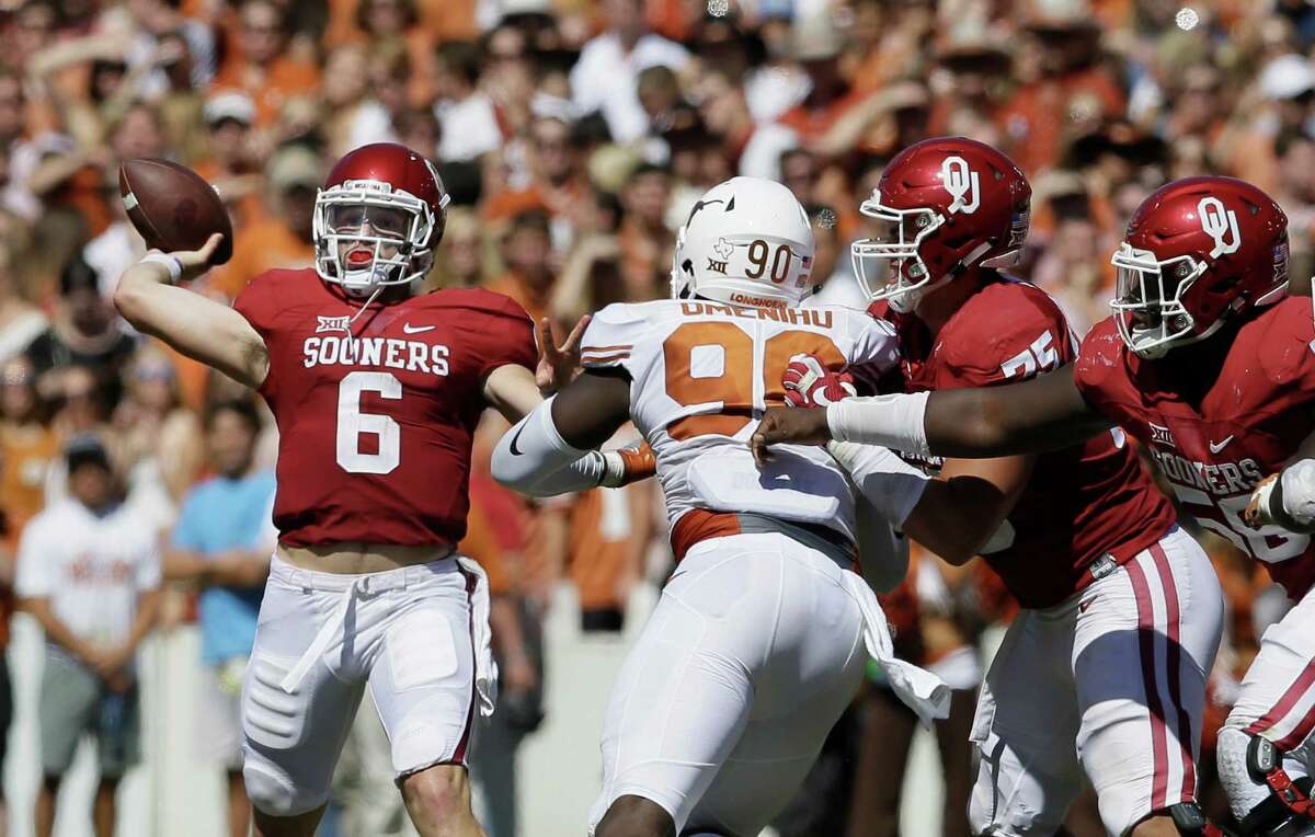 Oklahoma quarterback Baker Mayfield (6) throws a touchdown pass as offensive linemen Dru Samia (75) and Erick Wren (58) block Texas defensive end Charles Omenihu (90) during the second half of an NCAA college football game in Dallas, Saturday, Oct. 8, 2016. Oklahoma wide receiver Dede Westbrook caught the pass and Oklahoma won 45-40. (AP Photo/LM Otero)