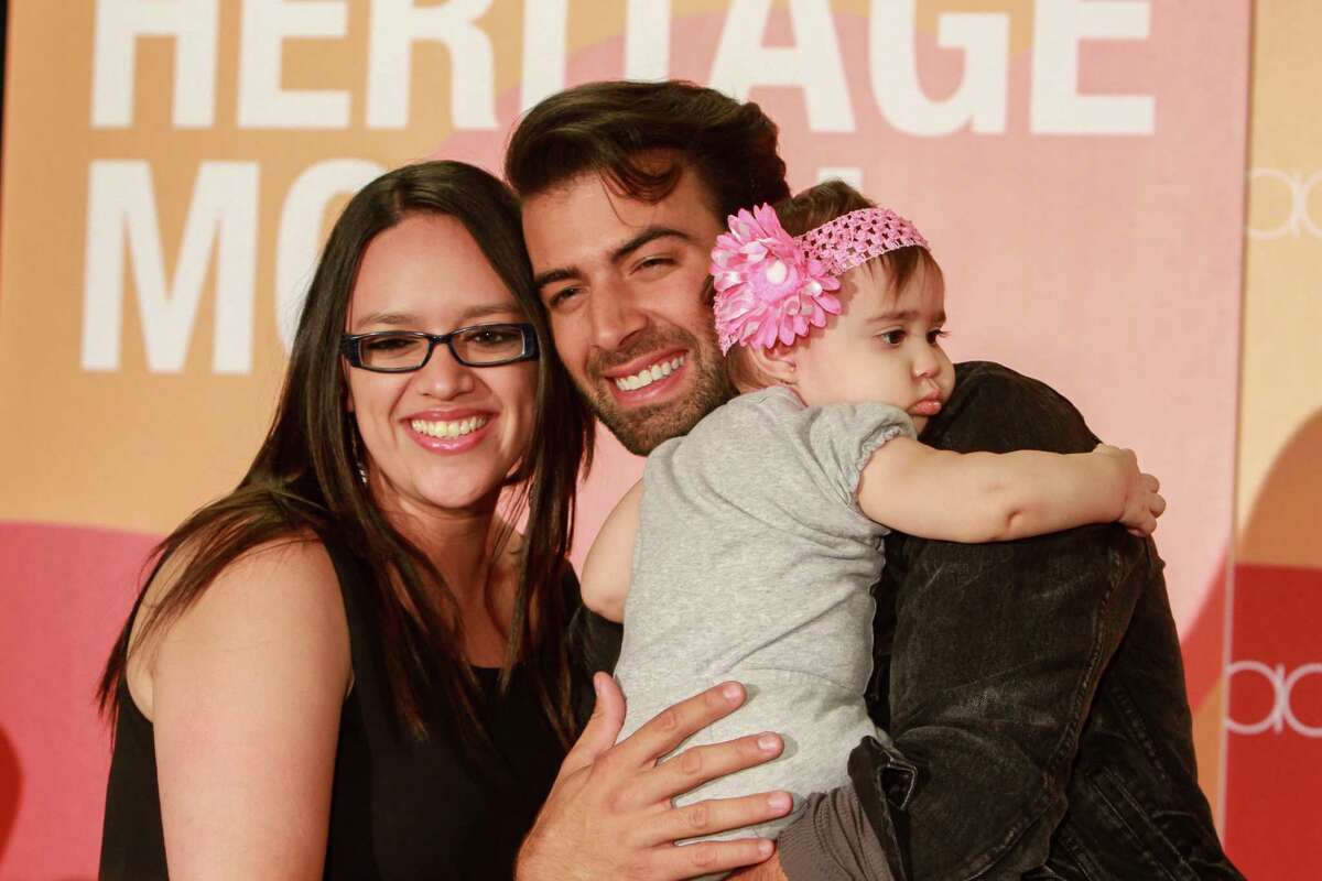 Angie Pereira and her ten-month-old daughter, Janelle, pose for a photo with singer-songwriter and actor, Jencarlos Canela at Macy's Memorial City. (For the Chronicle/Gary Fountain, October 8, 2016)