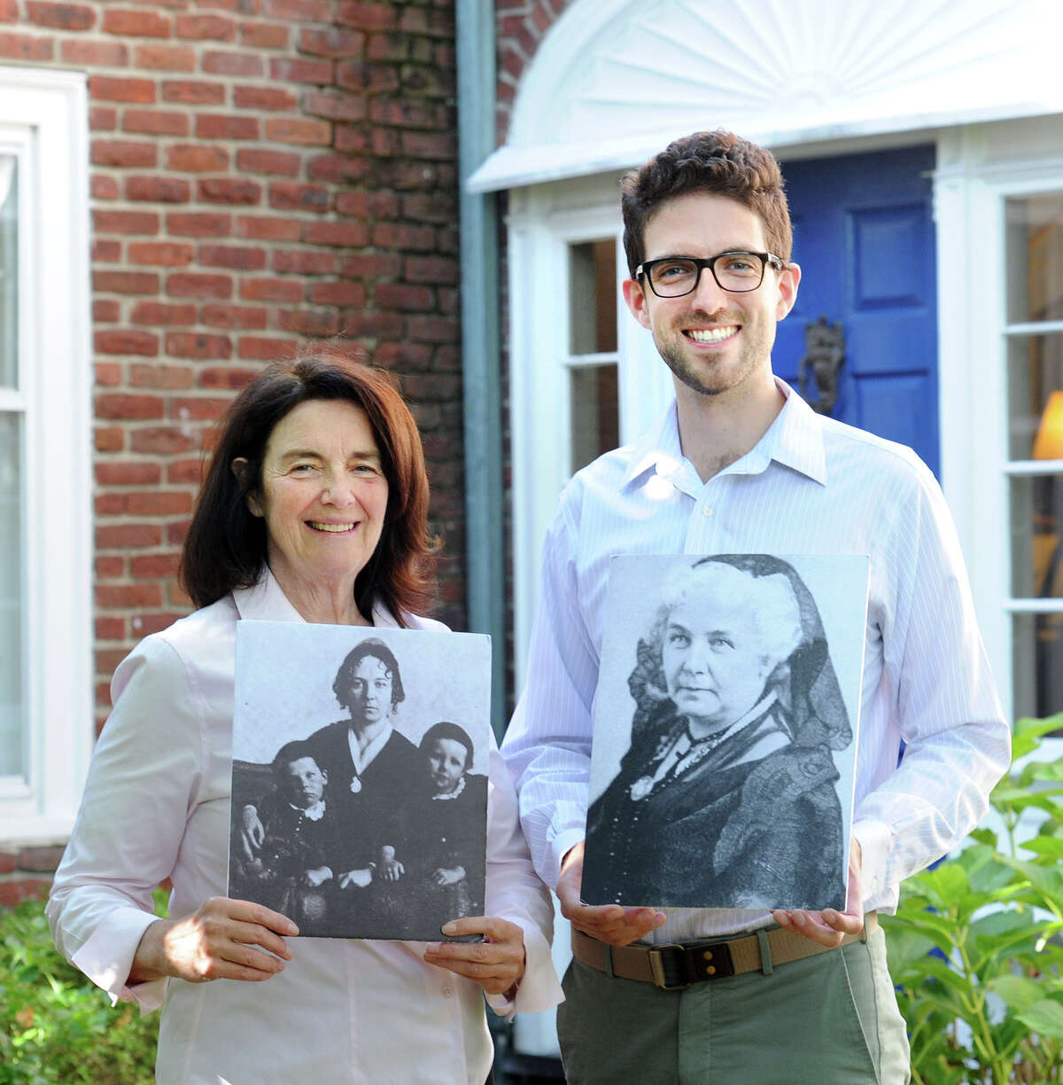 At left, Coline Jenkins, the great-great-granddaughter of Elizabeth Cady Stanton, and her son, Eric Jenkins-Sahlin, hold photos of Stanton, leader of the women’s suffrage movement, at their home in Greenwich, Conn., Thursday, Oct. 6, 2016. The Jenkins home was built in the 1930s by the state’s first female civil engineer, Nora Stanton Blatch Barney, Coline’s grandmother.