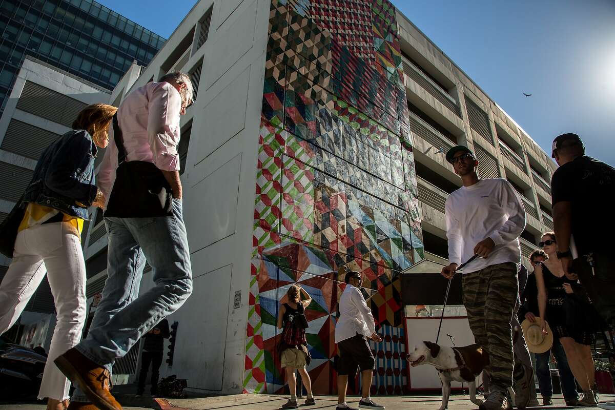 People check out the new murals during the Sites Unseen opening ceremony, Sunday, Oct. 9, 2016 in San Francisco, California. Sites Unseen is a public-art organization embarking on an ambitious program to install public art all around the South of Market neighborhood. Seven murals are on the Moscone parking garage just down from SFMOMA.