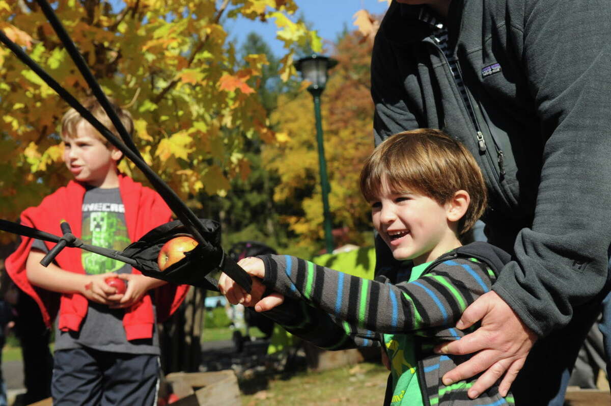 Jason O'Brien, 5, prepares to launch and apple as his brother Nicholas, 8, left, looks on at the Stamford Museum and Nature Center's Annual Harvest Festival Weekend in Stamford, Conn., Oct. 20, 2013.