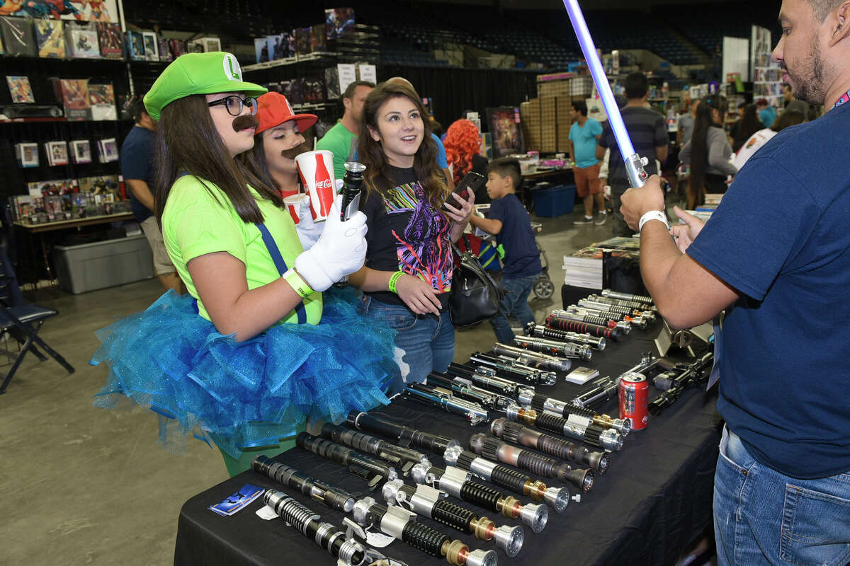 Mariana Garza, Karyme Lozano and Melissa Herrera react as they watch a lightsaber replica turn on, Sunday afternoon, during the last day of the South Texas Collectors Expo at the Laredo Energy Arena.