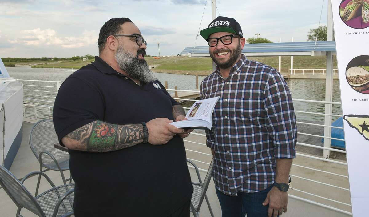 Sammy "The House" Ramirez, a contributor to the book The Tacos of Texas, discusses the book with Co-author Jarod Neece on Saturday evening during a Taco Party and book signing event at Alexander Crossing.