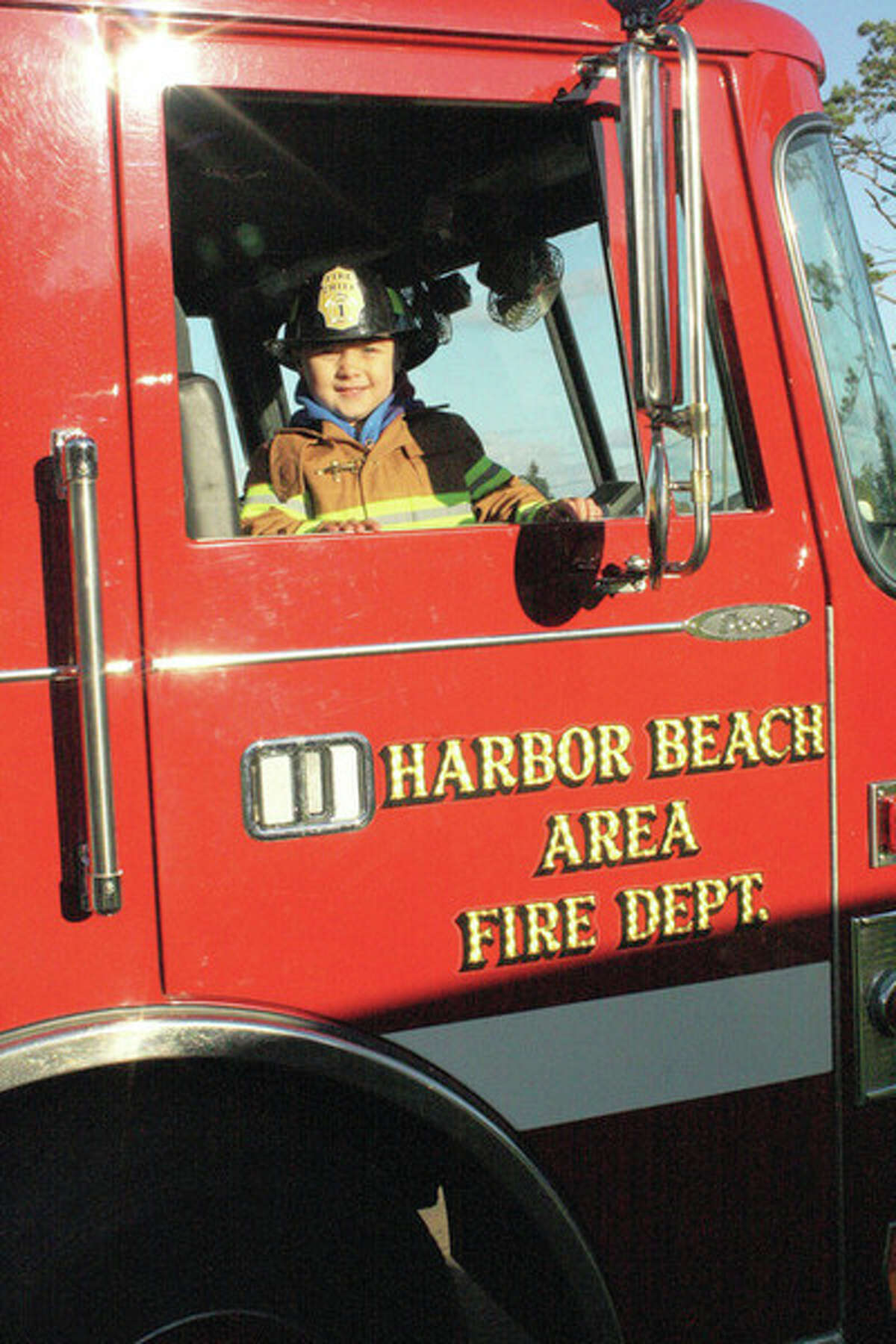 Harbor Beach firefighters can't resist letting Landon Libstaff stand in their fire truck after seeing his Halloween costume. The youngster and his Coast Guard family live in Harbor Beach, and they were part of the festivities at North Park on Saturday.