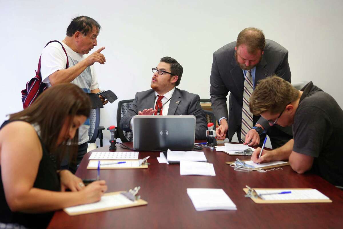Staff ﻿members at Harris County Tax Assessor-Collector Mike Sullivan's office help citizens register to vote﻿ Tuesday.