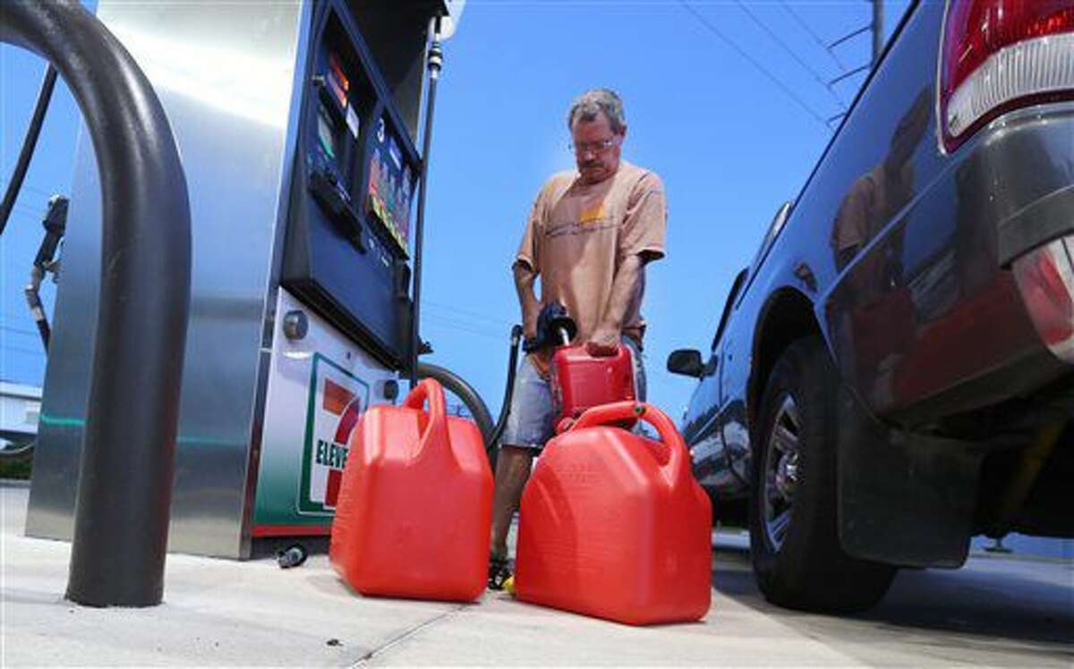 Jeff Beebe, of Cape Canaveral, Fla., fills gasoline containers, to be later used for his generator, Wednesday, Oct. 5, 2016, as Hurricane Matthew approaches Florida. Beebe is evacuating his home along with his 80 year old parents to Orlando. (Red Huber/Orlando Sentinel via AP)