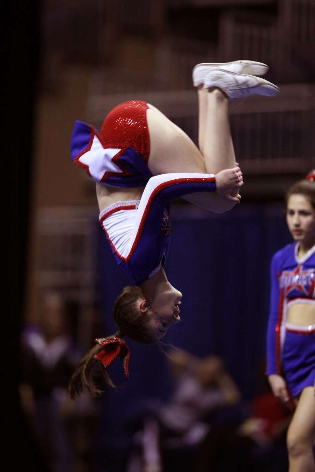 Cheerleader Tori Mann, of Greenwich, does a back tuck during a performance tumbling pass.