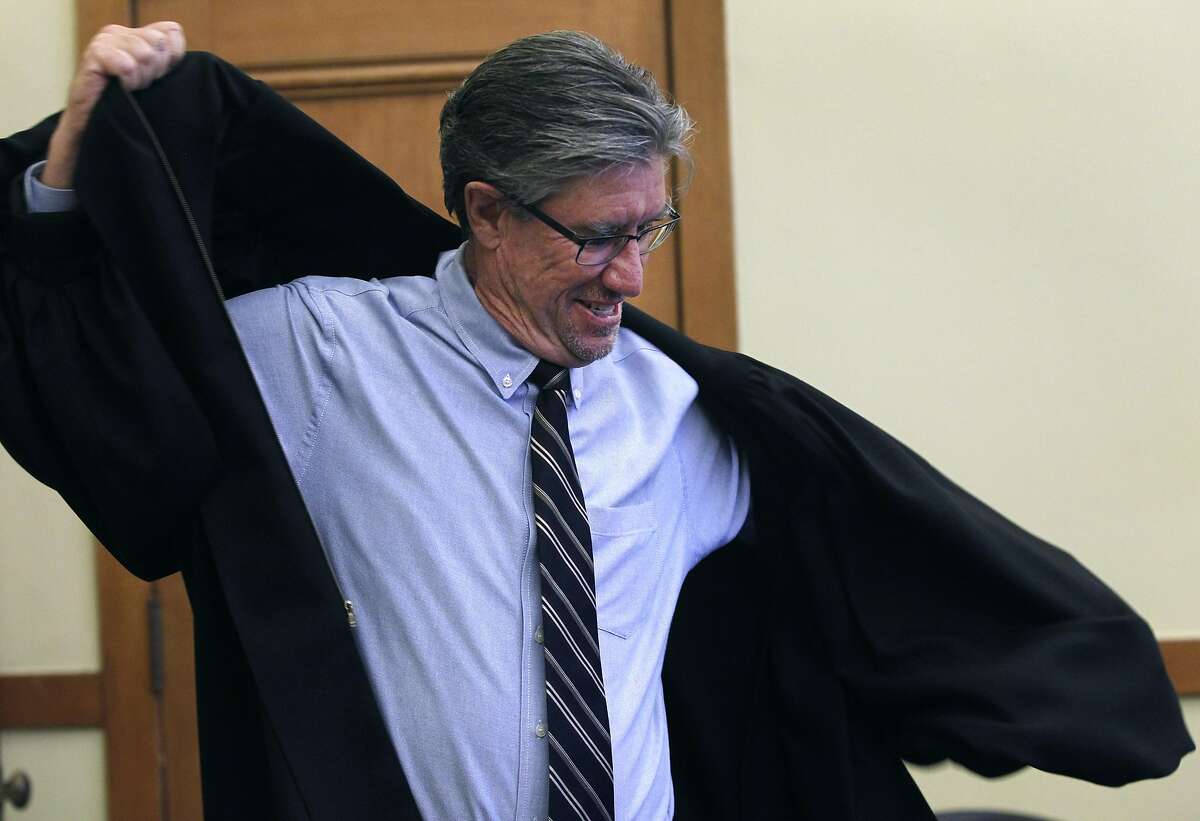 C.W. Nevius dons a ceremonial robe for his role as a marriage commissioner for a day before conducting weddings at City Hall in San Francisco, Calif. on Friday, Sept. 4, 2015.