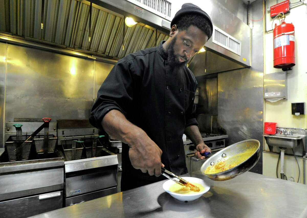 Jean Gabriel, co-owner/chef of Soul Tasty, plates Cajun Shrimp and Grits (below), one of the signature dishes for the new soul food restaurant in Stamford.