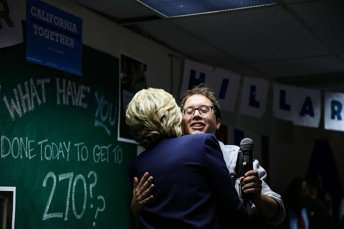 U.S. Democratic Presidential nominee Hillary Clinton hugs regional organizer Billy Cline (right), during an event at the DNC headquarters on Van Ness Avenue in San Francisco, California, on Thursday, Oct. 13, 2016.