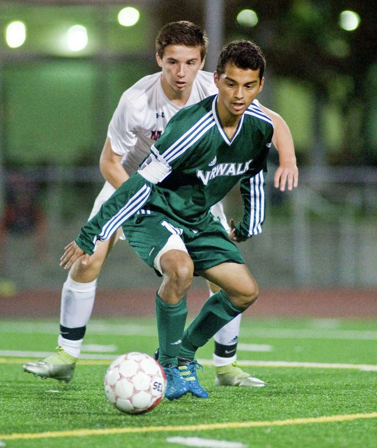 McMahon’s George Simpson and Norwalk’s Anthony Hernandez move in on the ball.