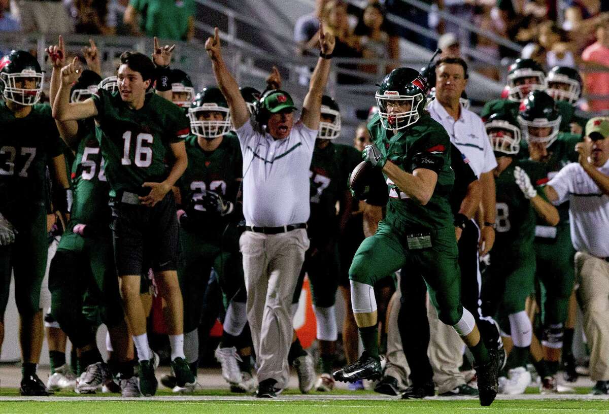 The Woodlands head coach Mark Schmid celebrates as linebacker Grant Milton (21) returns an interception for a 50-yard touchdown during the second quarter of a District 12-6A high school football game at Woodforest Bank Stadium Thursday, Oct. 13, 2016, in Shenandoah.