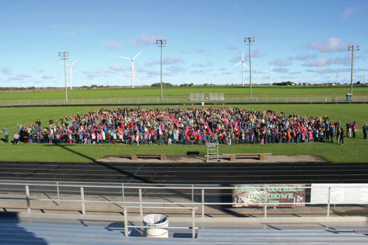 Everyone gathered on the football field Thursday to receive a Michigan-grown Gala apple, provided by Countryview Market in Snover, and they took a bite of their apple and raised their healthy snack in the air for a photo opportunity.