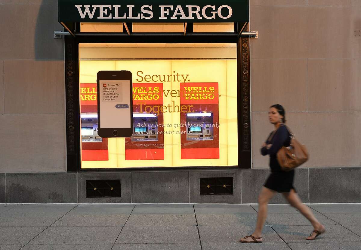 (FILES) This file photo taken on October 5, 2016 shows a woman walking past a Wells Fargo bank in Washington, DC. Large US banks reported lower third-quarter earnings on October 14, 2016 but beat analyst expectations, as Wells Fargo pledged anew to win back consumer trust after a bogus accounts scandal. Profits from JPMorgan Chase, Citigroup and Wells Fargo for the third quarter were lower compared with the year-ago period, revealing anew the drag on margins from ultra-low interest rates. / AFP PHOTO / ANDREW CABALLERO-REYNOLDSANDREW CABALLERO-REYNOLDS/AFP/Getty Images