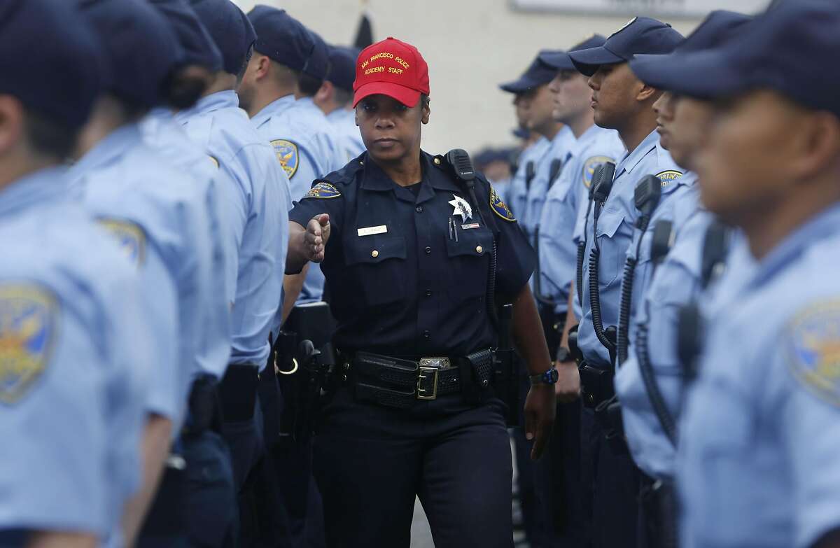 Recruit training officer Edie Lewis (center) checks the formation of recruits and their uniforms as they stand in formation during an exercise at the San Francisco Police Academy Regional Training Center on Wednesday, June 10, 2015 in San Francisco, Calif.