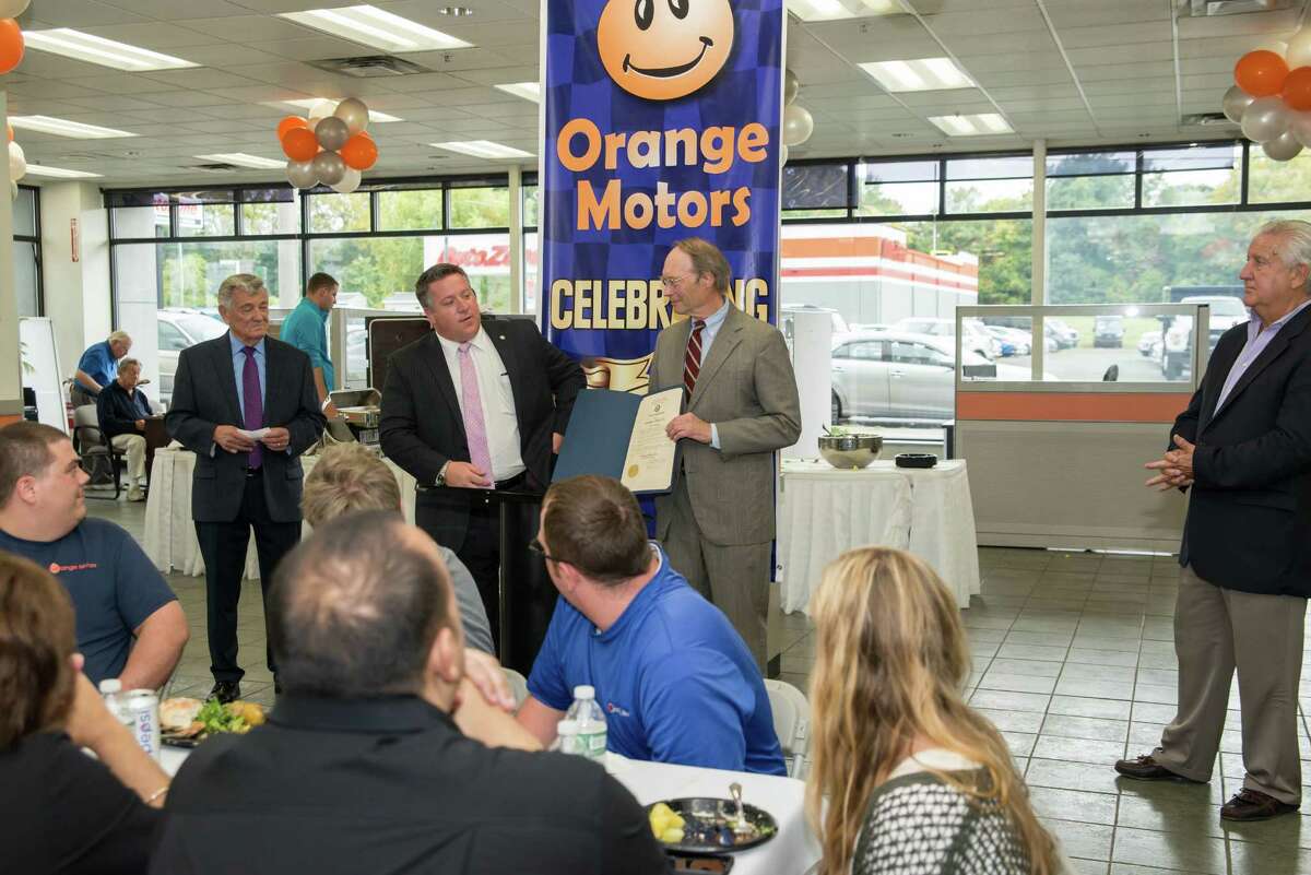 Orange Motors celebrates its 100th anniversary. Above, from left, General Manager Carl Keegan, who's been with the dealership for 45 years, Albany County Executive Dan McCoy, dealership owner Charles Touhey, and former Albany Mayor Gerald Jennings. The event was held Thursday.