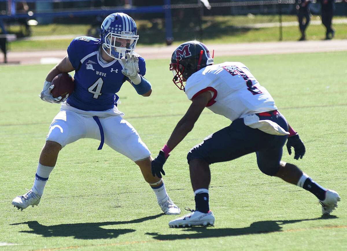Darien's Maxwell Grant, left, gets ready to put a move on Brien McMahon defensive back Luis Vigo en route to a 60-yard touchdown pass during the first quarter of Saturday's FCIAC football game in Darien. The host Blue Wave coasted to a 54-17 win.