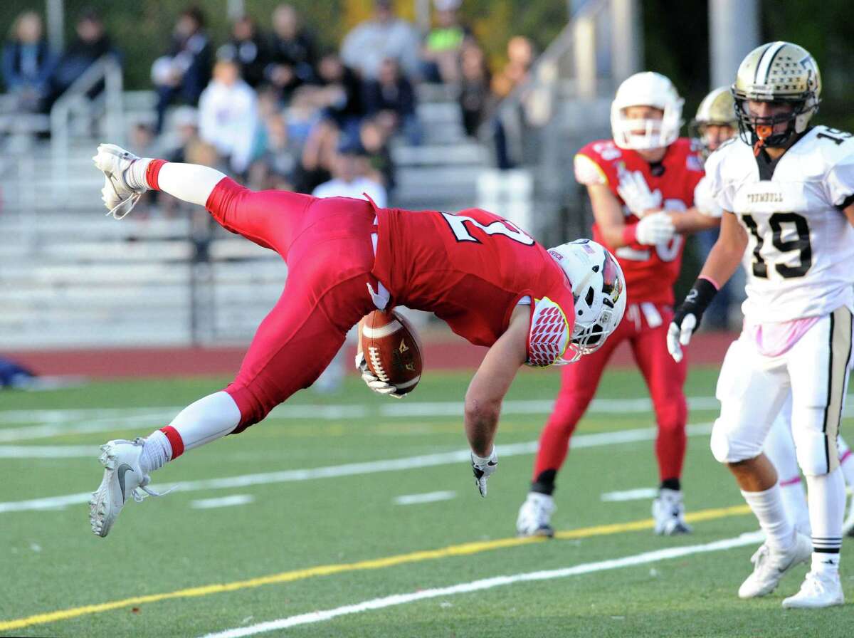 Greenwich running back Kevin Iobbi leaps into the endzone to score during the fourth quarter as at Trumbull’s Dustin Siqueira looks on during the Cardinal’s 42-32 victory on Saturday in Greenwick.