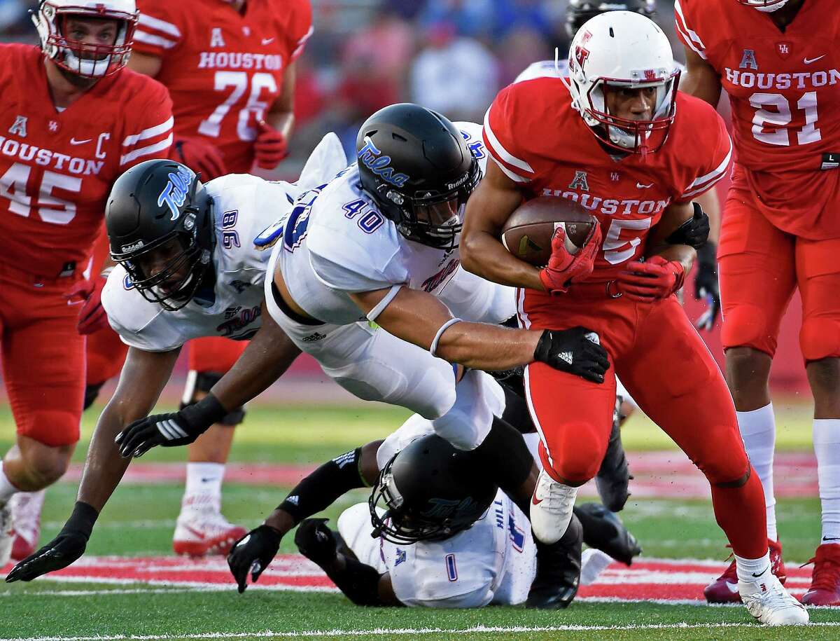 Houston running back Dillon Birden, right, escapes the tackle of Tulsa linebacker Trent Martin (40) in the first half of an NCAA college football game, Saturday, Oct. 15, 2016, in Houston. (AP Photo/Eric Christian Smith)