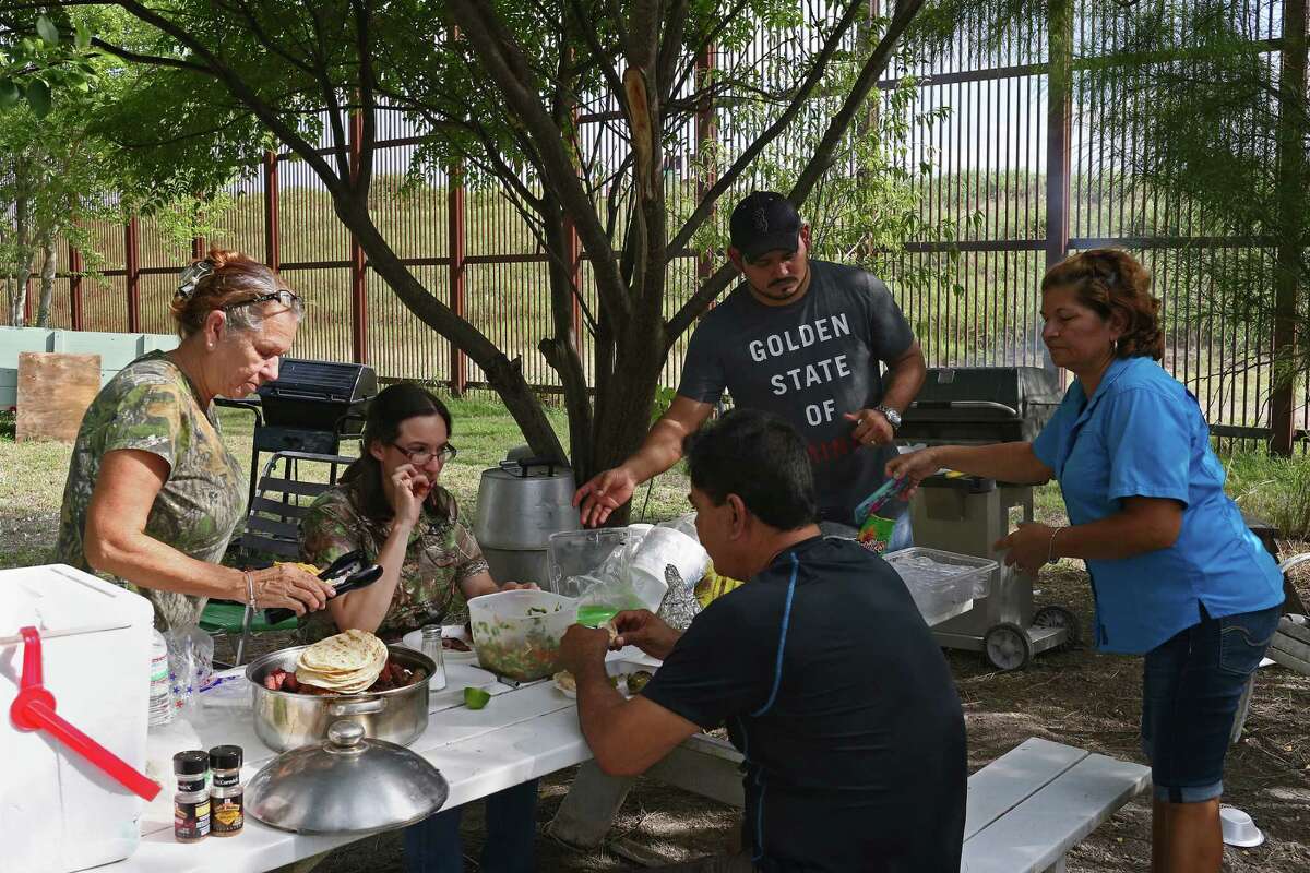 In La Lomita neighborhood of Brownsville, Texas, the Granados family grills in their backyard, Sunday, Oct. 2, 2016. The neighborhood is next to the U.S.-Mexico border wall and serves as a backdrop to the family's Dallas Cowboys game-watch cookouts. The younger Edgar Granados said, ?’You can build anything, they?•ll still get through.?“ The family has witness immigrants scale the wall in under a minute.