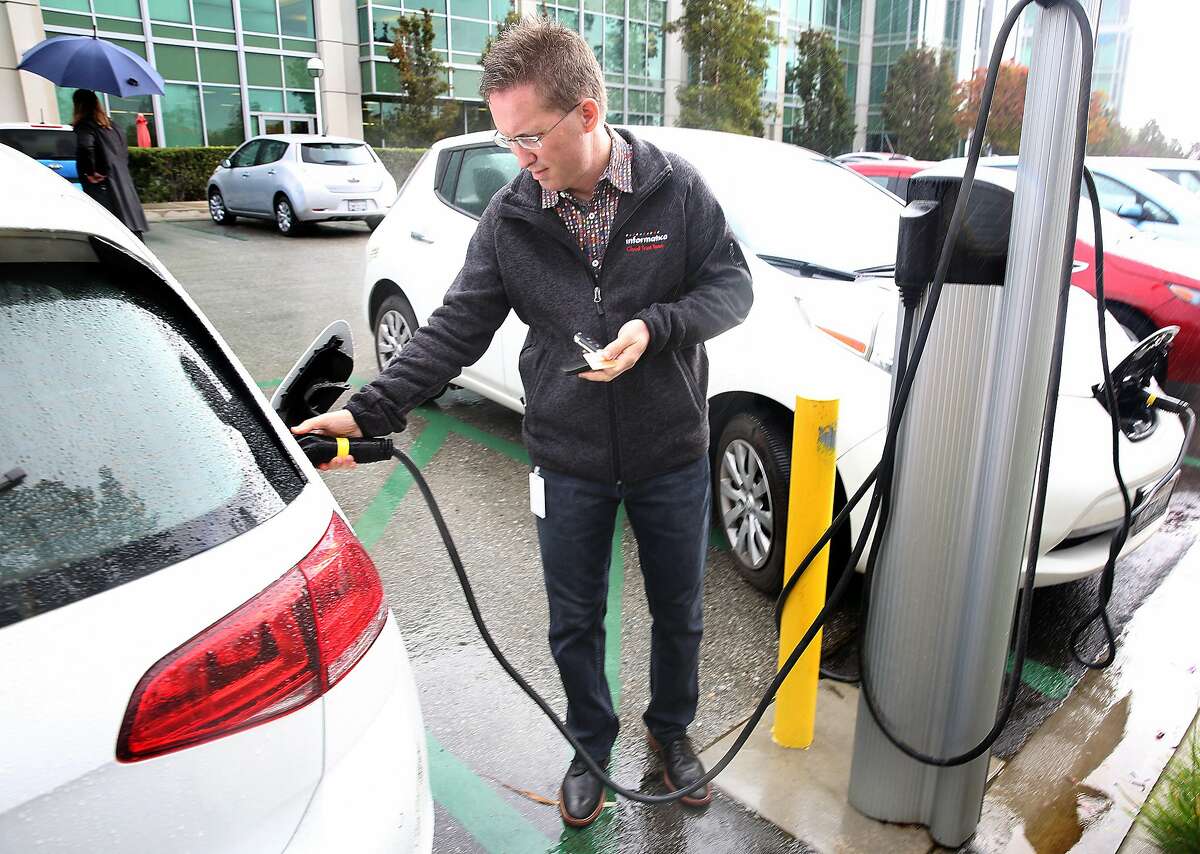Informatica vice president Bill Burns disengages the plug after receiving a message from Waitlist that his car is fully charged on Friday, October 14, 2016, in Redwood City, Calif.