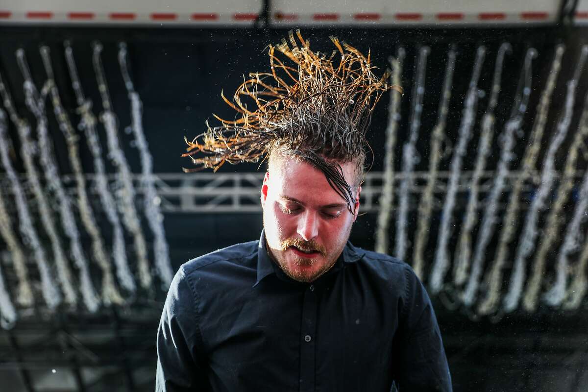 George Clarke of Deafheaven flips his hair while performing on the second day of the Treasure Island Music Festival in San Francisco, California, on Sunday, Oct. 16, 2016.