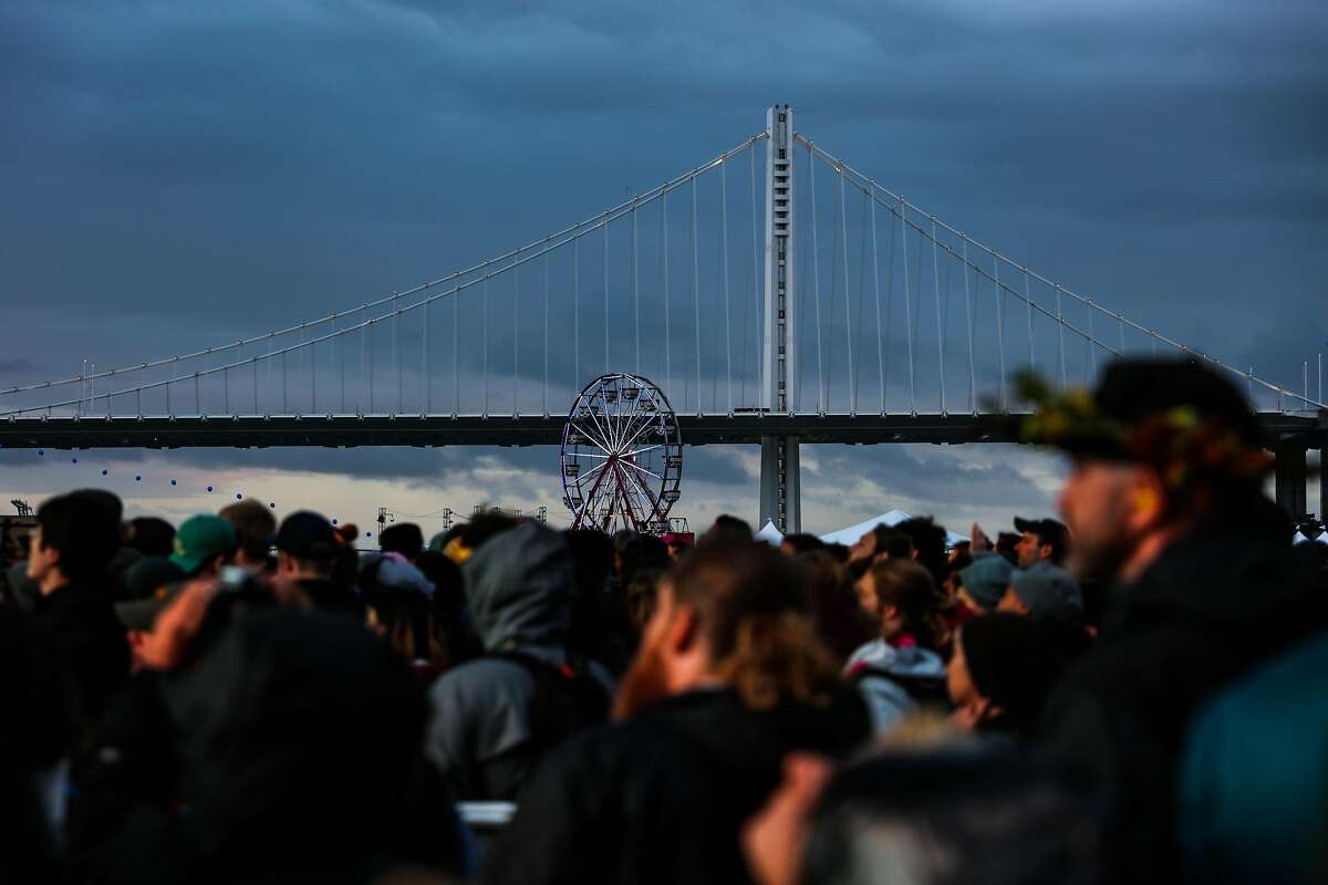The Bay Bridge is seen through a crowd of people, at the Treasure Island Music Festival in San Francisco, California, on Sunday, Oct. 16, 2016.