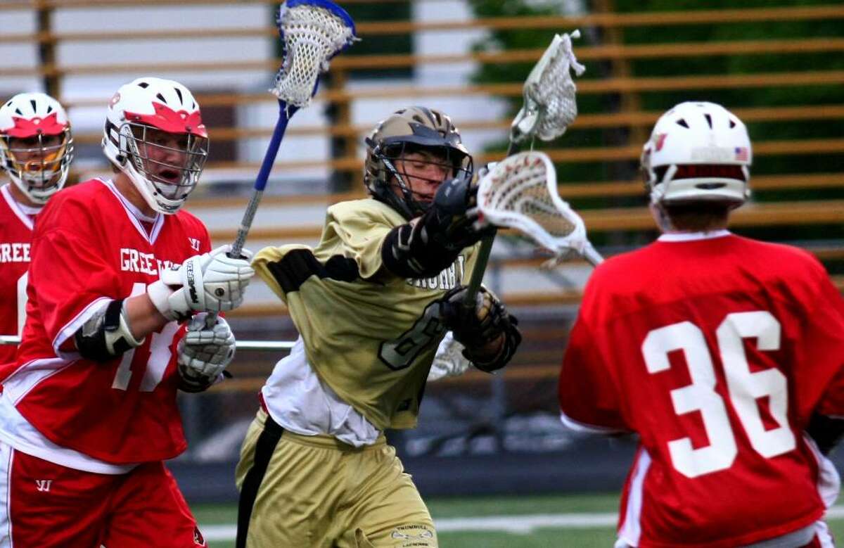 Trumbull's #6 Mitch Latorre, in center, looks to break away from Greenwich's #13 Daniel Noskin, left, and #36 Fritz Waine, during boys lacrosse action in Trumbull, Conn. on Wednesday May, 12, 2010.
