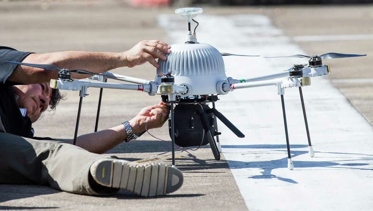 David Dunaway, of Intuitive Machines, attaches the tether line to a drone during a tethered drone system demonstration at the company's new facility at the Houston Spaceport on Monday, Oct. 17, 2016, in Houston. The drone flew to 400 feet and performed a surveillance demonstration including assent tracking, real time monitoring. ( Brett Coomer / Houston Chronicle )