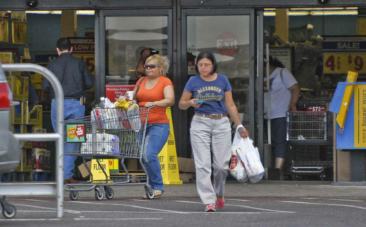Shoppers exit the H-E-B on San Dario Avenue and Del Mar Boulevard in Laredo, with plastic bags full of groceries, in this 2014 file photo. Laredo is among several Texas cities attempting to regulate the use of the bags and is fighting for its ordinance in the courts.